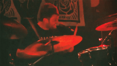 Man Playing Drums With Decals Shirt