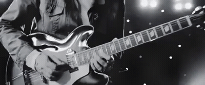 Man Playing Electric Guitar On Stage Black And White GIF