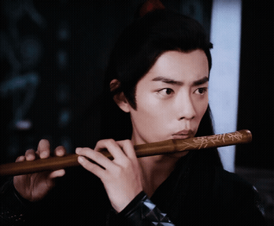 Man Playing Flute In Dark Room GIF