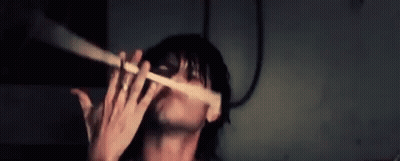 Man Playing Flute In Dark Room With Mask GIF
