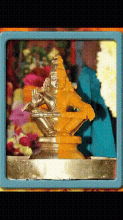Man Playing Flute Statue With Flowers GIF