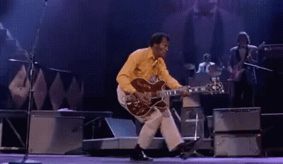 Man Playing Guitar And Dancing On Stage GIF