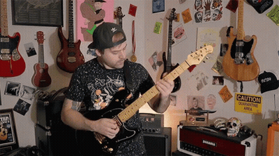 Man Playing Guitar By Caution Sign GIF