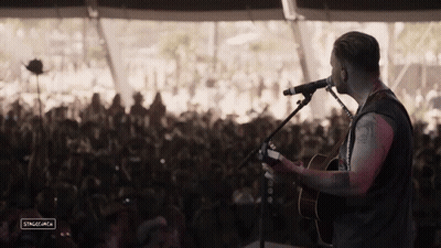 Man Playing Guitar In Front Of Crowd GIF