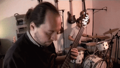 Man Playing Guitar In Front Of Drums GIF
