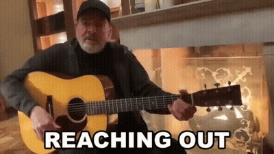 Man Playing Guitar In Front Of Fireplace Reaching Out GIF