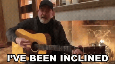 Man Playing Guitar In Front Of Fireplace Saying I've Been Inclined GIF