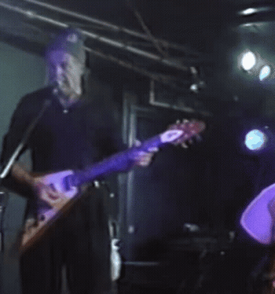 Man Playing Guitar in Front of Microphone