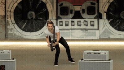 Man Playing Guitar In Front Of O Wall GIF