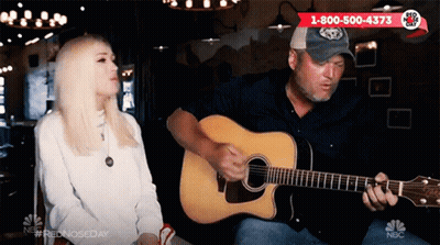 Man Playing Guitar in Front of Sitting Woman
