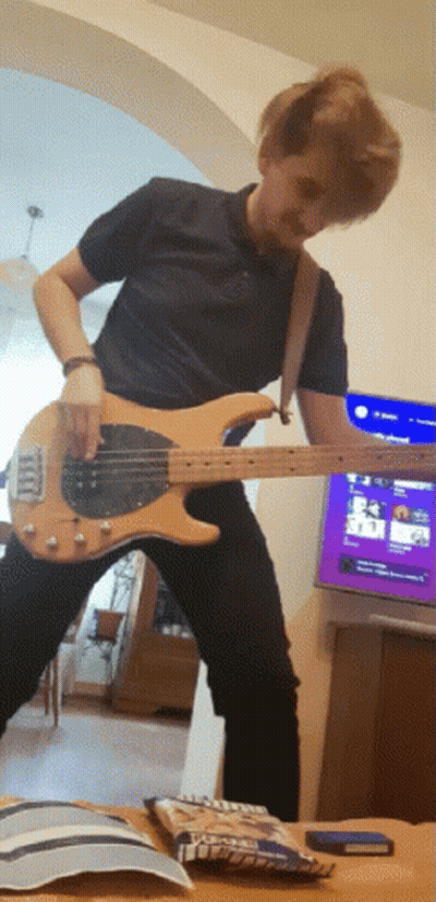 Man Playing Guitar In Front Of TV And M&Ms GIF