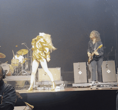 Man Playing Guitar Next To Woman On Stage GIF