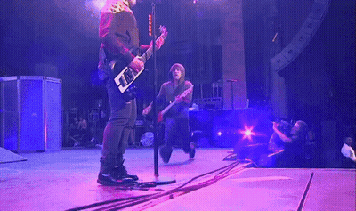 Man Playing Guitar On Stage With Purple Lights GIF