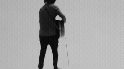 Man Playing Guitar On Stool Black And White GIF