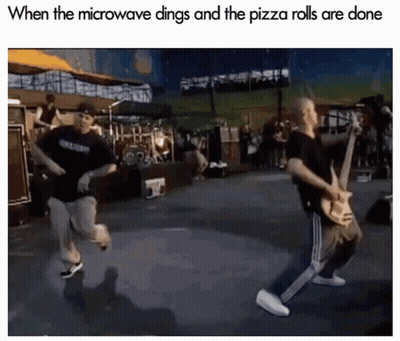 Man Playing Guitar While Another Runs On Stage GIF