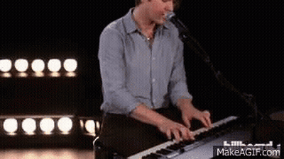 Man Playing Keyboard And Singing On Stage GIF