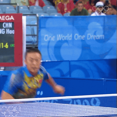 Man Playing Ping Pong In Front Of One World One Dream Sign GIF