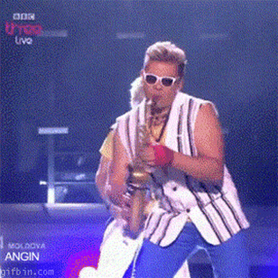 Man Playing Saxophone In Front Of BBC U-Top Live Screen GIF