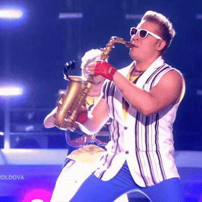 Man Playing Saxophone In Front Of Moldova Sign GIF