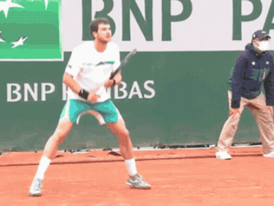 Man Playing Tennis In Front Of BNP Banner GIF