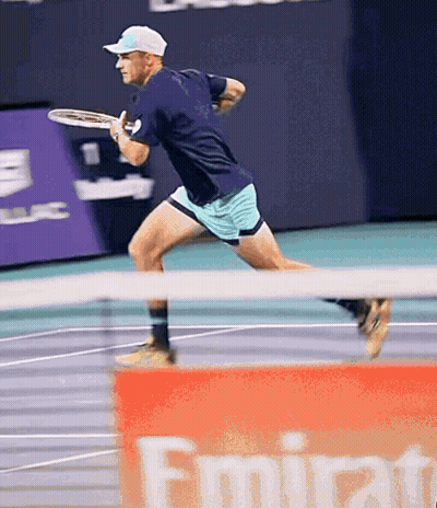 Man Playing Tennis In Front Of Emirates Banner GIF