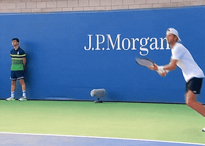 Man Playing Tennis In Front Of J.P. Morgan Sign GIF