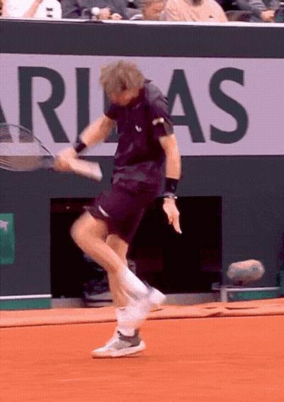 Man Playing Tennis In Front Of Rias Sign GIF