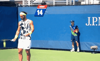 Man Playing Tennis In Front Of Wall With Number 14 GIF