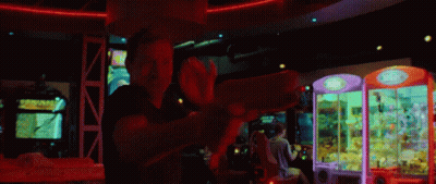 Man Playing Video Game In Arcade With Claw Machine GIF