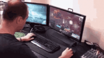 Man Playing Video Game On Two Monitors GIF