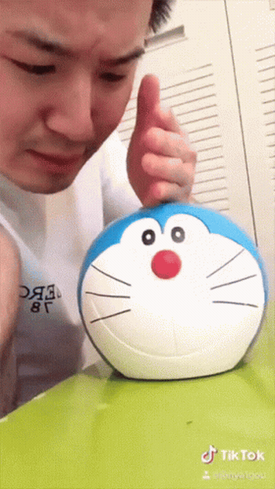 Man Playing With Stuffed Doraemon GIF