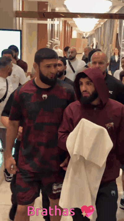Man Pointing At Another Man's Head In Front Of Screen GIF