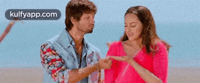 Man Pointing At Woman's Finger On Beach GIF