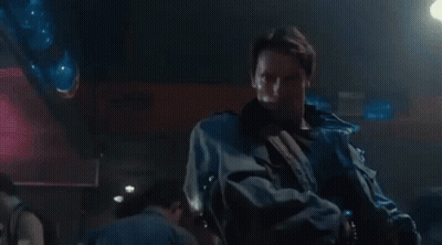 Man Pointing Gun At Another Man In Dark Room GIF