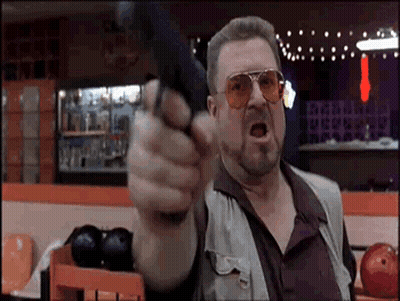 Man Pointing Gun At Camera In Bowling Alley GIF