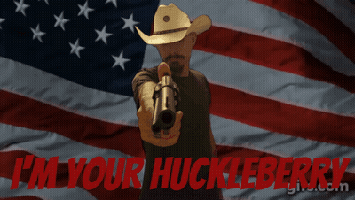 Man Pointing Gun In Front Of American Flag Saying I'm Your Huckleberry GIF