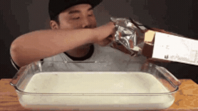 Man Pouring Butter Into Glass Dish Of Milk GIF