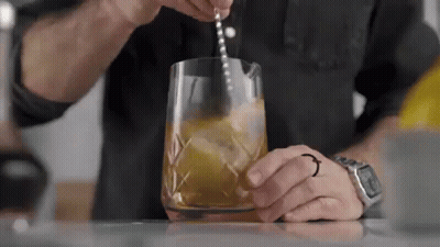 Man Pouring Drink Into Glass With Spoon GIF