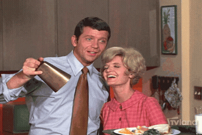 Man Pouring Drink Into Woman's Mouth With TVLand Logo GIF