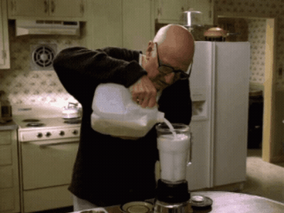 Man Pouring Milk Into Blender In Kitchen GIF