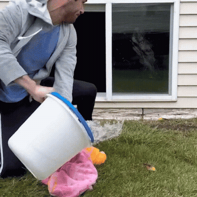 Man Pouring Water From White Bucket Into Pink Towel GIF