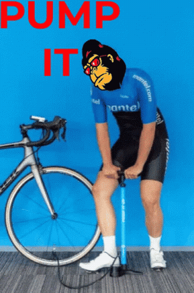 Man Pumping Tire Next to Bicycle Saying Pump It