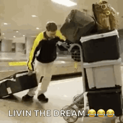 Man Pushing Luggage Cart Saying Livin The Dream GIF