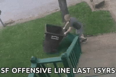Man Pushing Trash Can Over Green Railing GIF