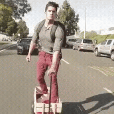 Man Pushing Wagon Down Street GIF