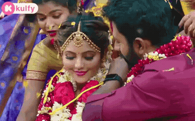 Man Putting Garland On Woman's Neck GIF