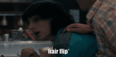 Man Putting Hand On Woman's Shoulder Saying Hair Flip GIF