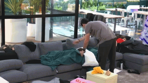 Man Putting Pillow On Woman GIF