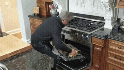 Man Putting Something In Oven In Kitchen GIF