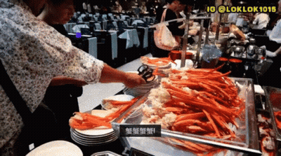 Man Reaching Into Tray Of Crab Legs With Tongs GIF